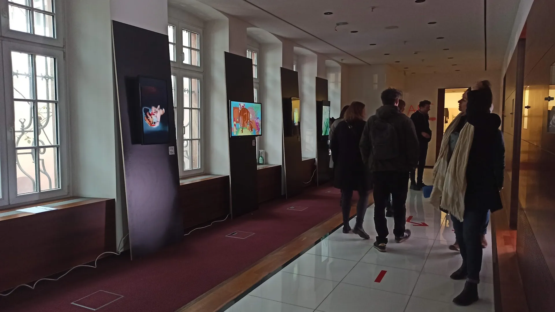 Besucher:innen gehen an Displays im Bethmannhof vorbei